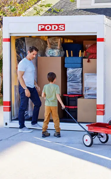 A family loading their belongings into a PODS container